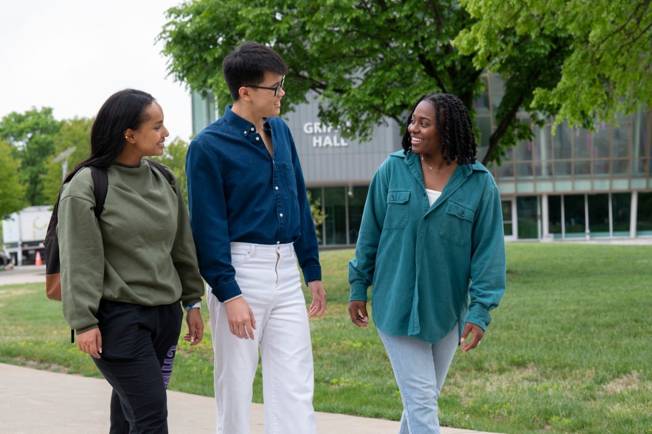 Three students walking by Griffin Hall