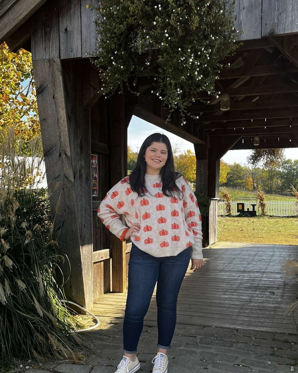 Photo of student standing outside in a sweatshirt in jeans.