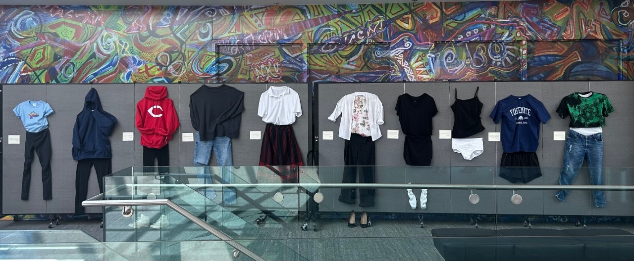 Row of outfits displayed on a wall