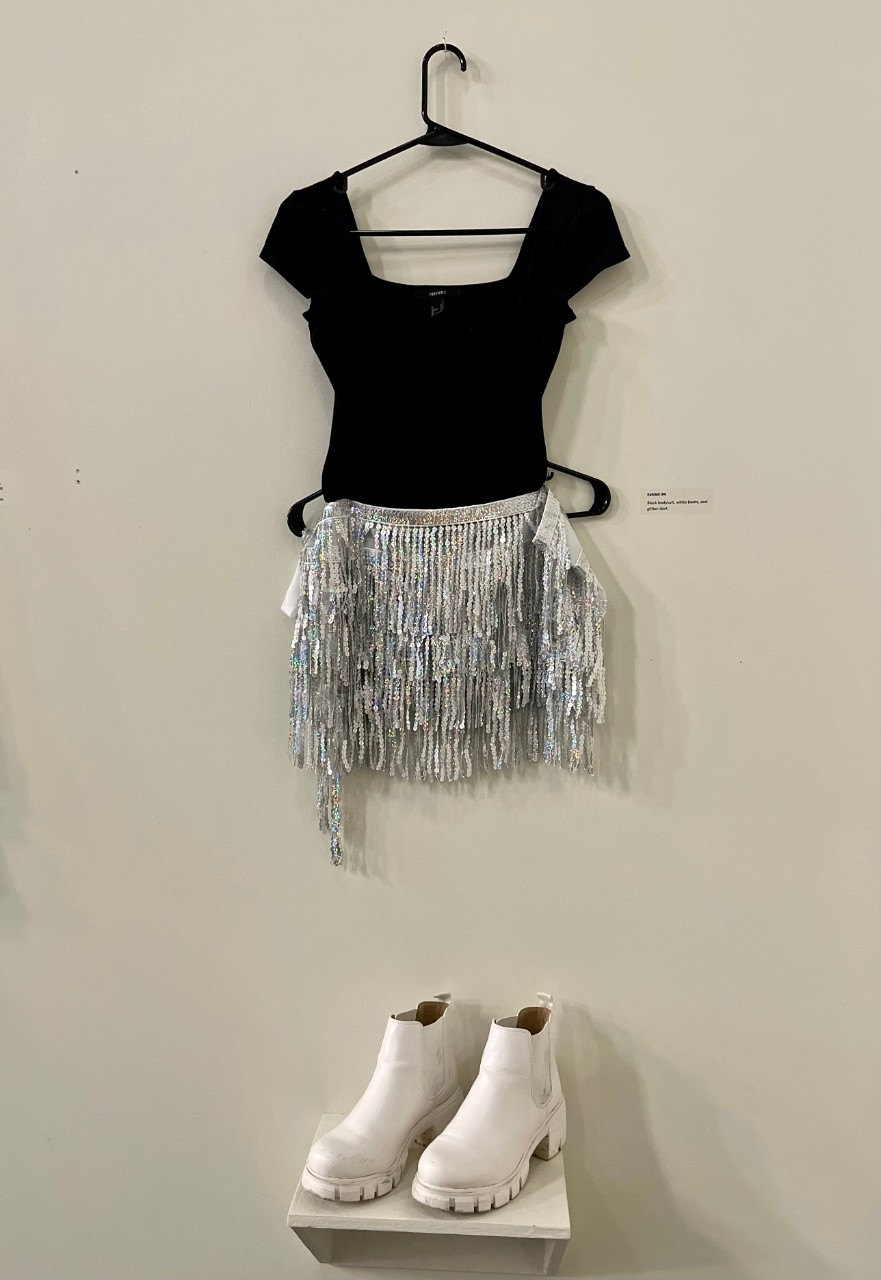 Black bodysuit, silver glitter skirt, white ankle length boots