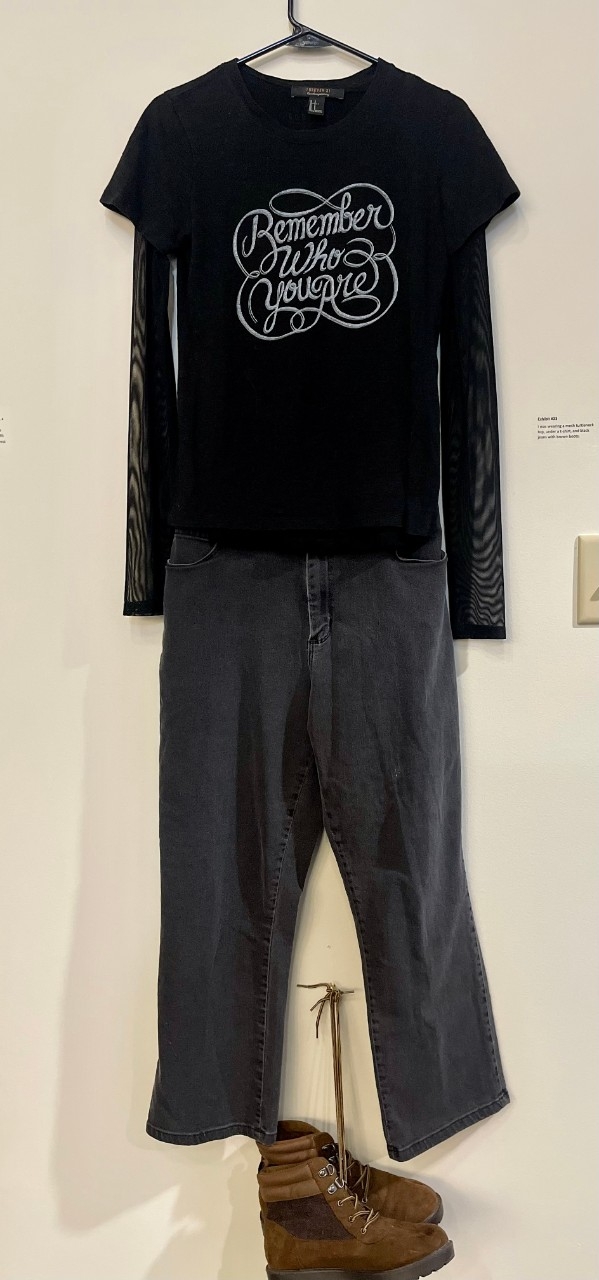 A black t-shirt over a black long-sleeved shirt, black jeans, and brown boots