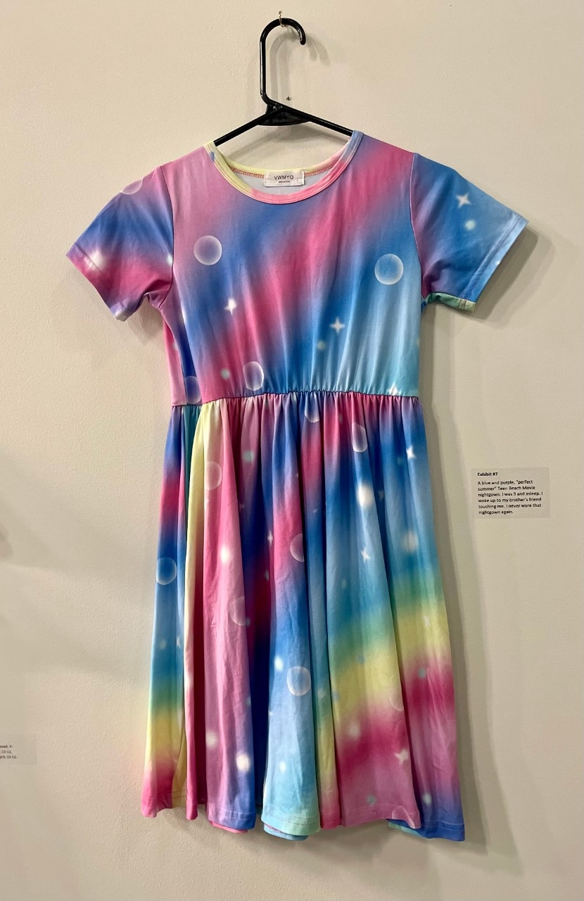 Child's blue dress with faded rainbow colors across and small bubbles printed on fabric