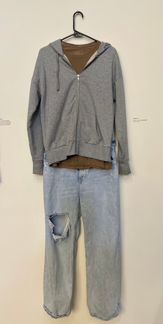 Jeans with a hole in the knee, brown t-shirt, with gray hoodie.