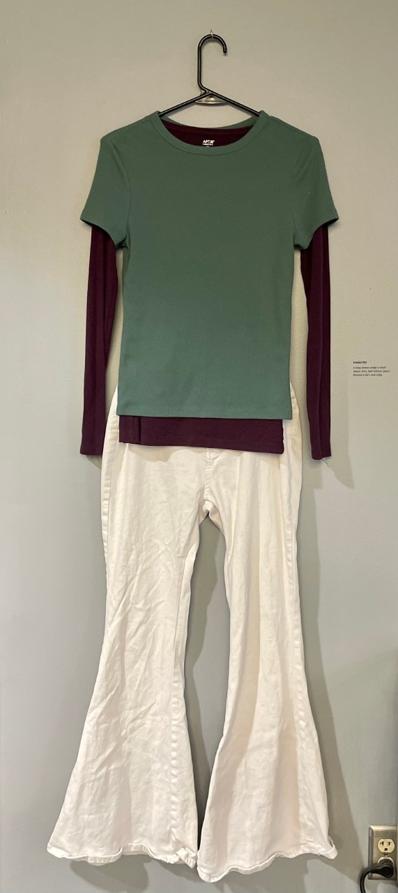 Green t-shirt, purple long sleeve shirt under it. White bell bottom pants