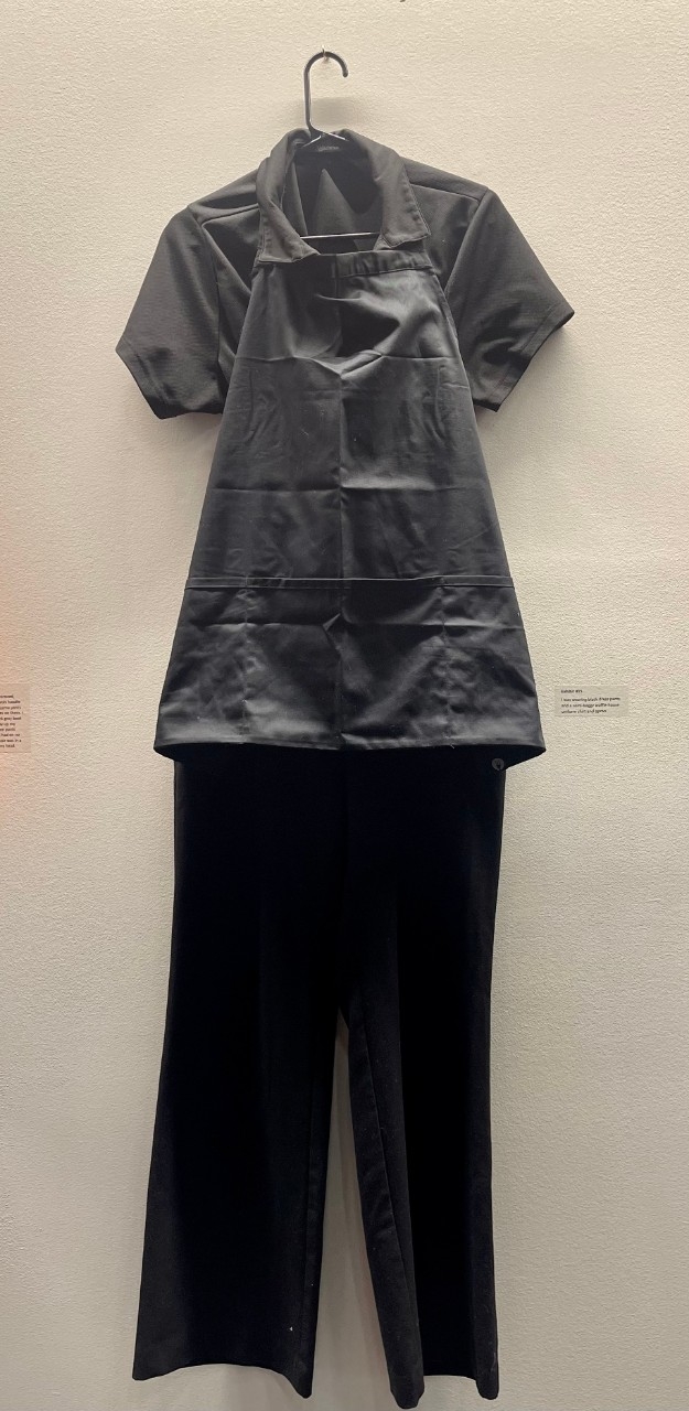 Black polo shirt, black pants, and black apron.