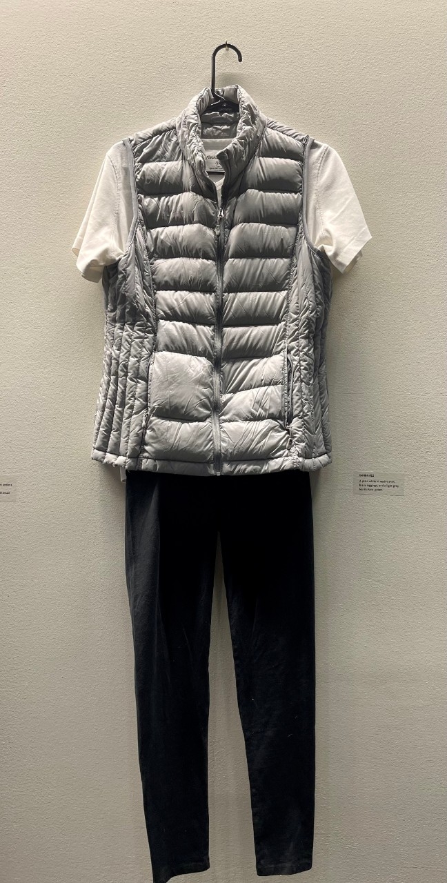 white tshrit under a gray vest and black leggings