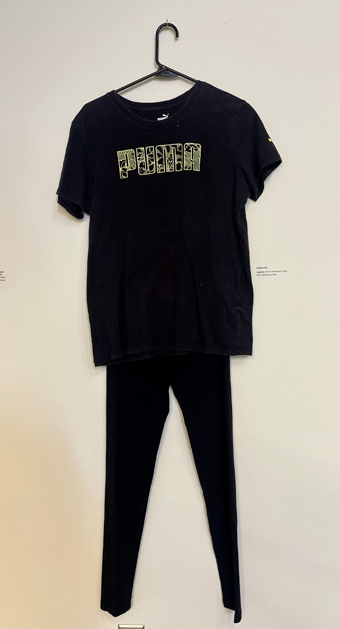 Black t-shirt with camo lettering that says "PUMA". Black leggings