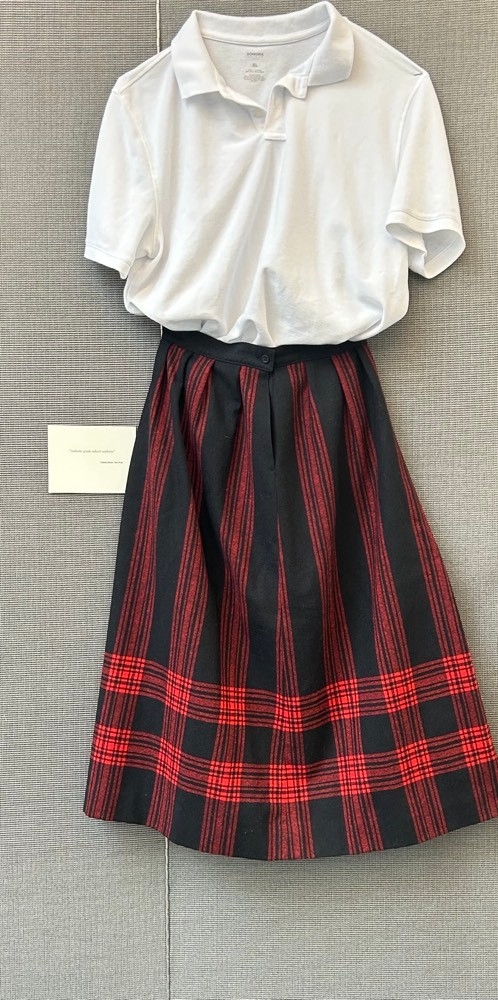 White polo shirt with red and black plaid skirt