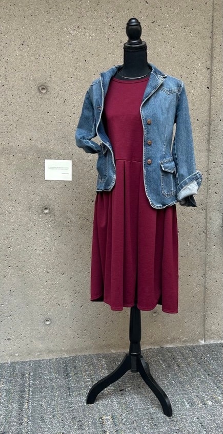 Red dress with denim jacket overtop and wire necklace