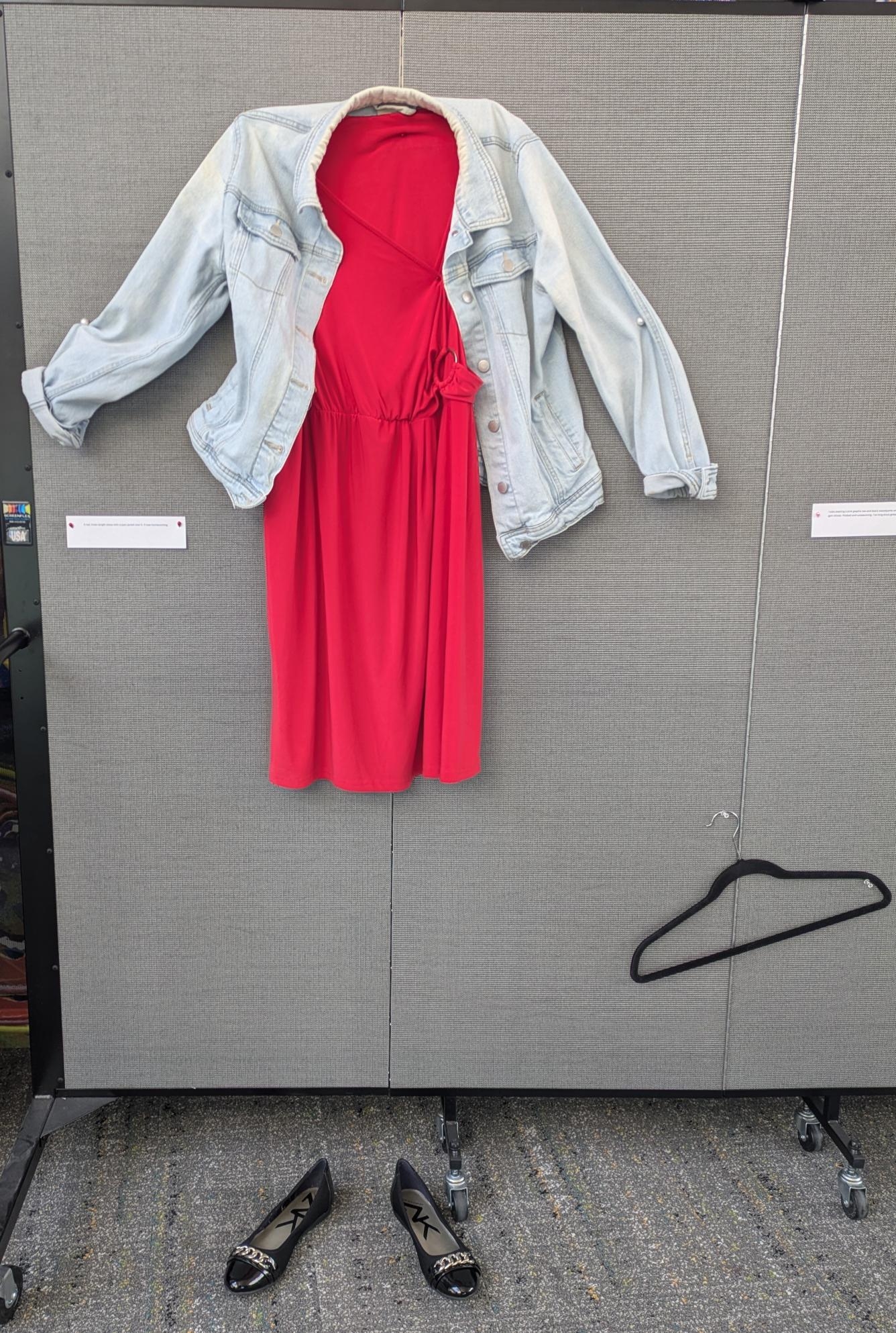 Red knee length dress with jean jacket over it.