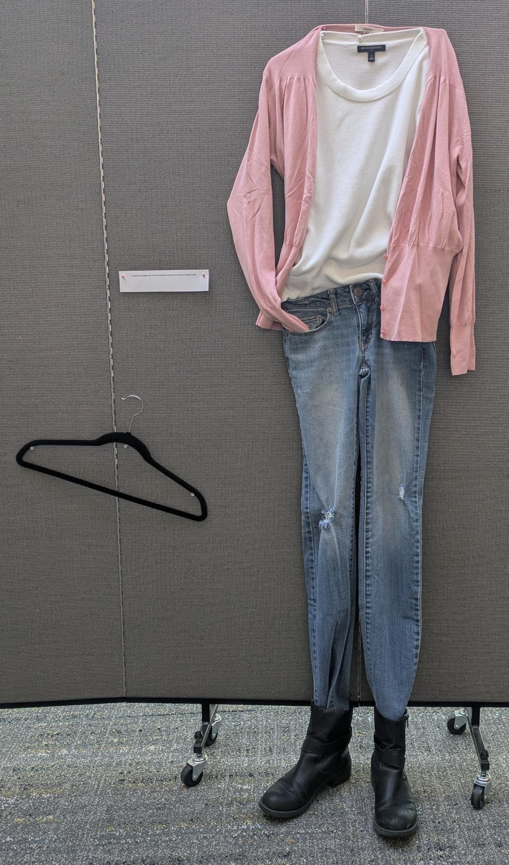 White shirt with pink cardigan, jeans, and black boots.