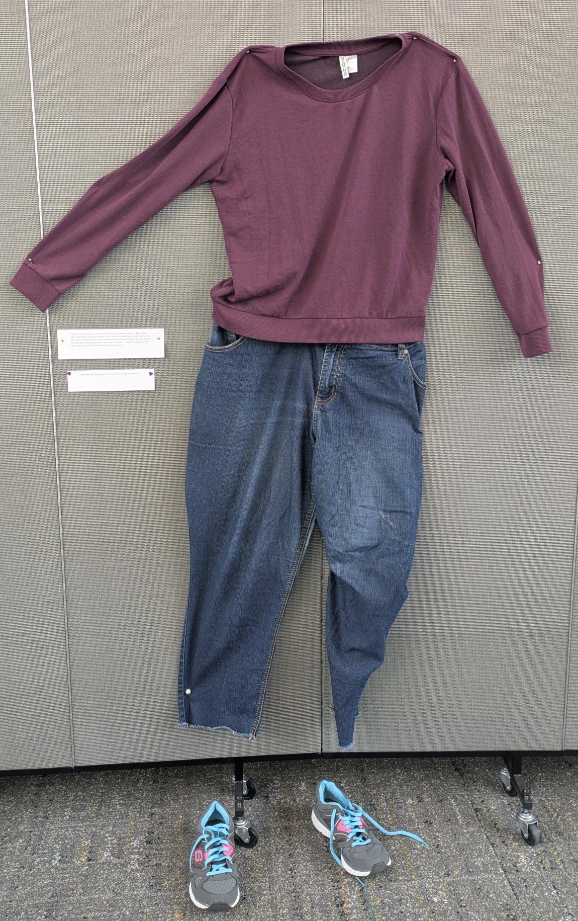 Long-sleeved purple pullover with jeans and gray sneakers.