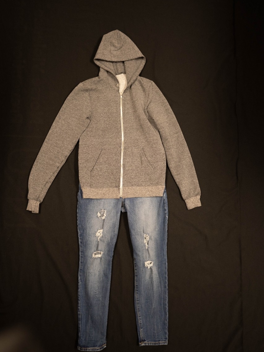 Exhibit displays a gray hoodie with ripped jeans.