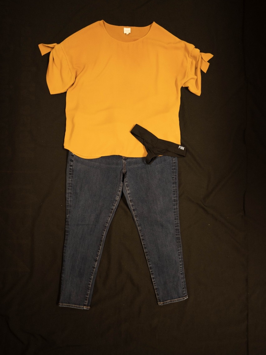 Exhibit displays a standard pair of jeans with a yellow blouse and black underwear.