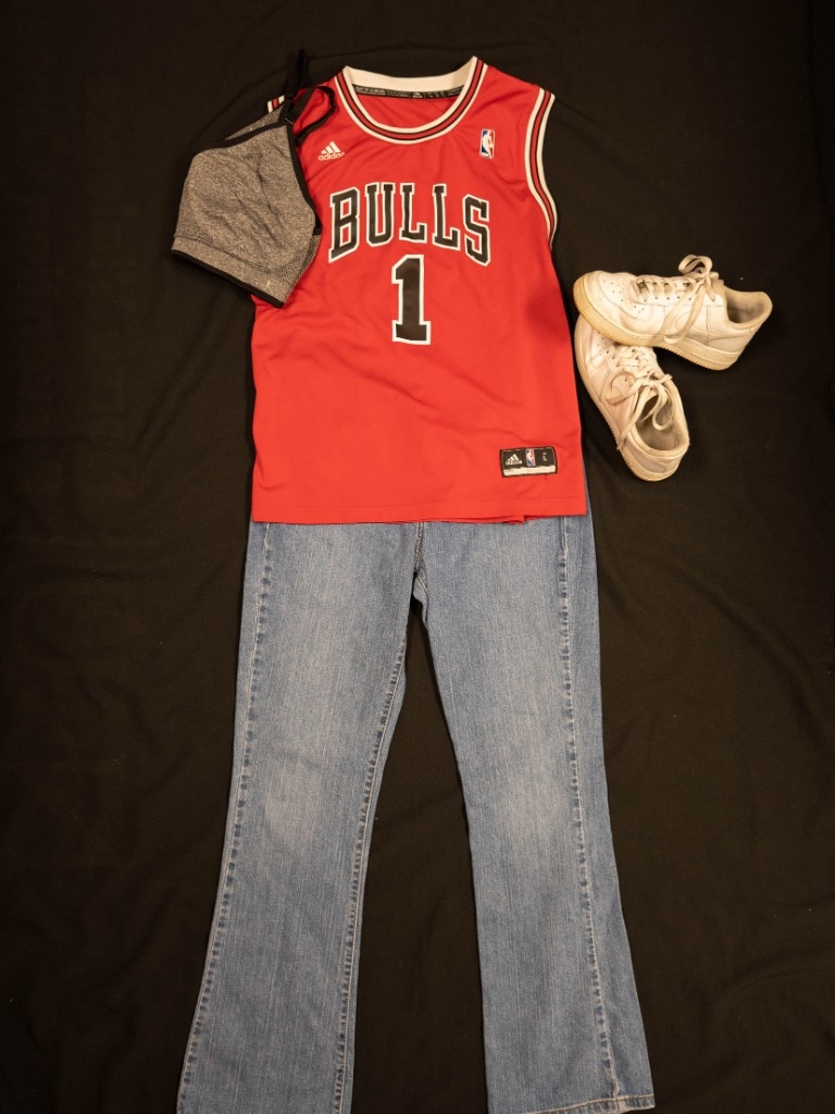 Exhibit displays a red jersey, black sports bra, standard jeans and white tennis shoes.