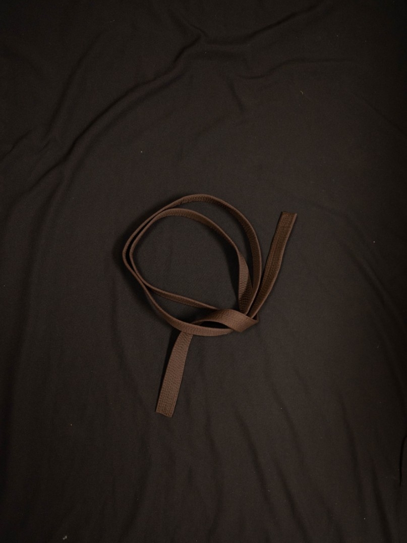 Exhibit displays a child’s brown karate belt. 