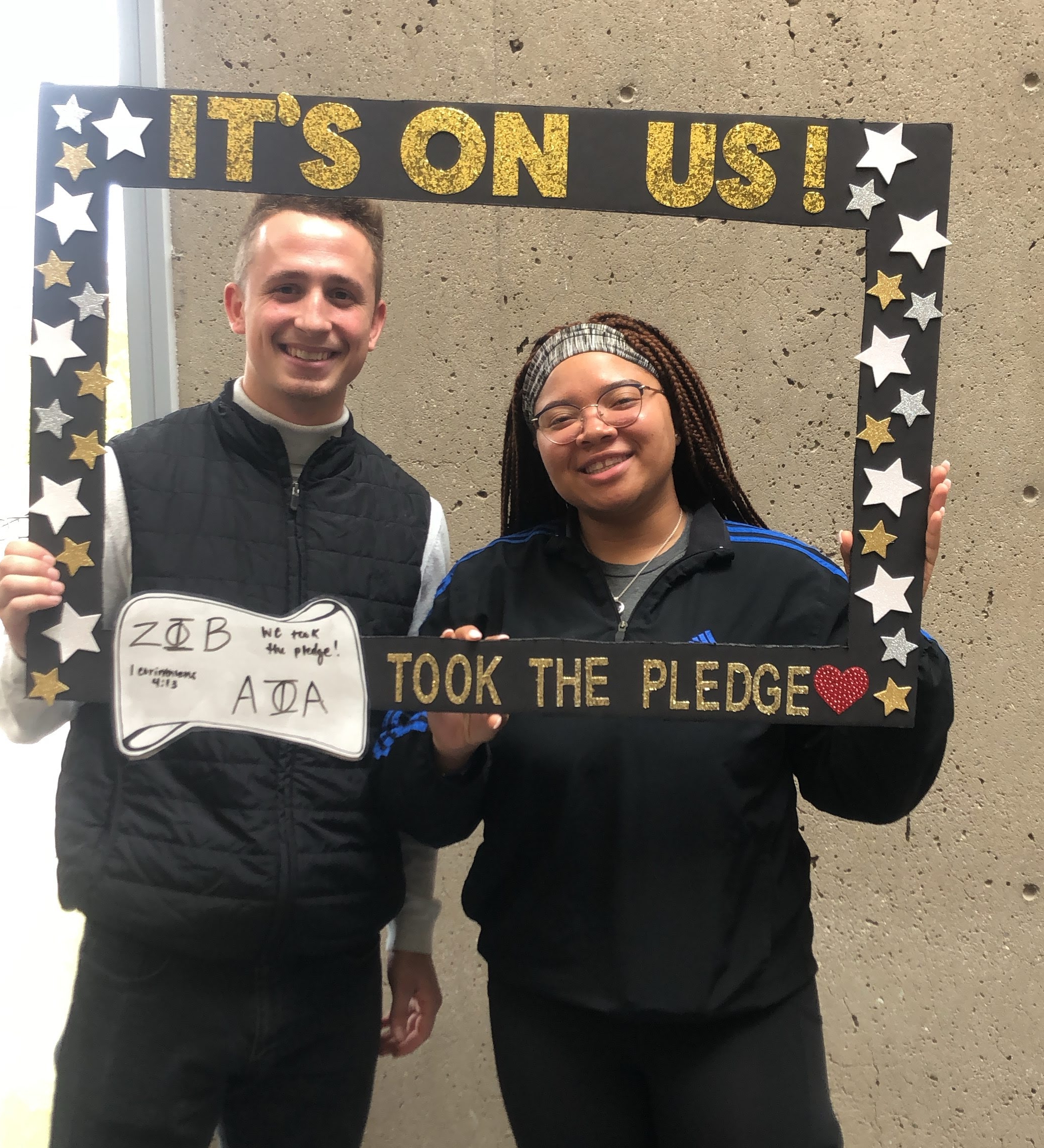 Two students holding photo frame with It's On Us pledge