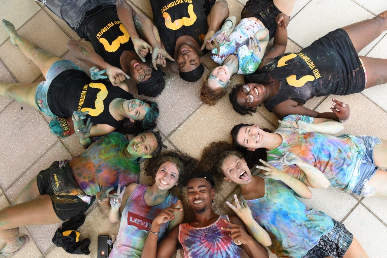 NKU Students lying on the ground in a circle, staring up at the camera and smiling