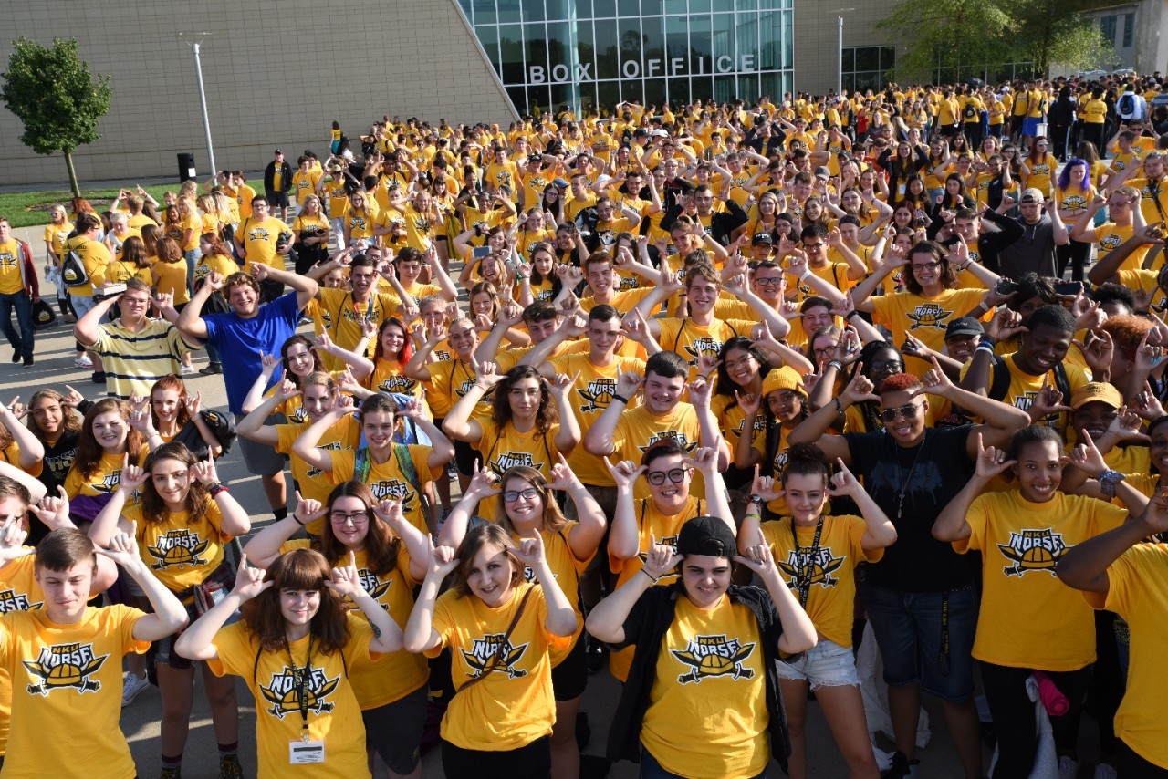 NKU Students doing the "Norse Up" symbol while smiling at the camera in a large group