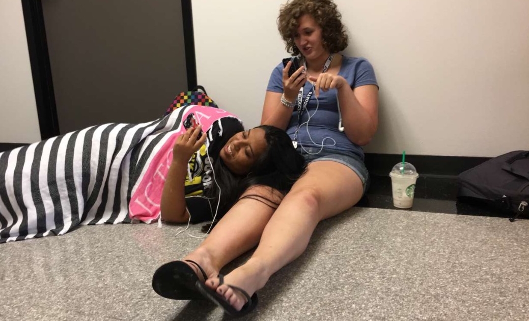 Two students on floor looking at phones