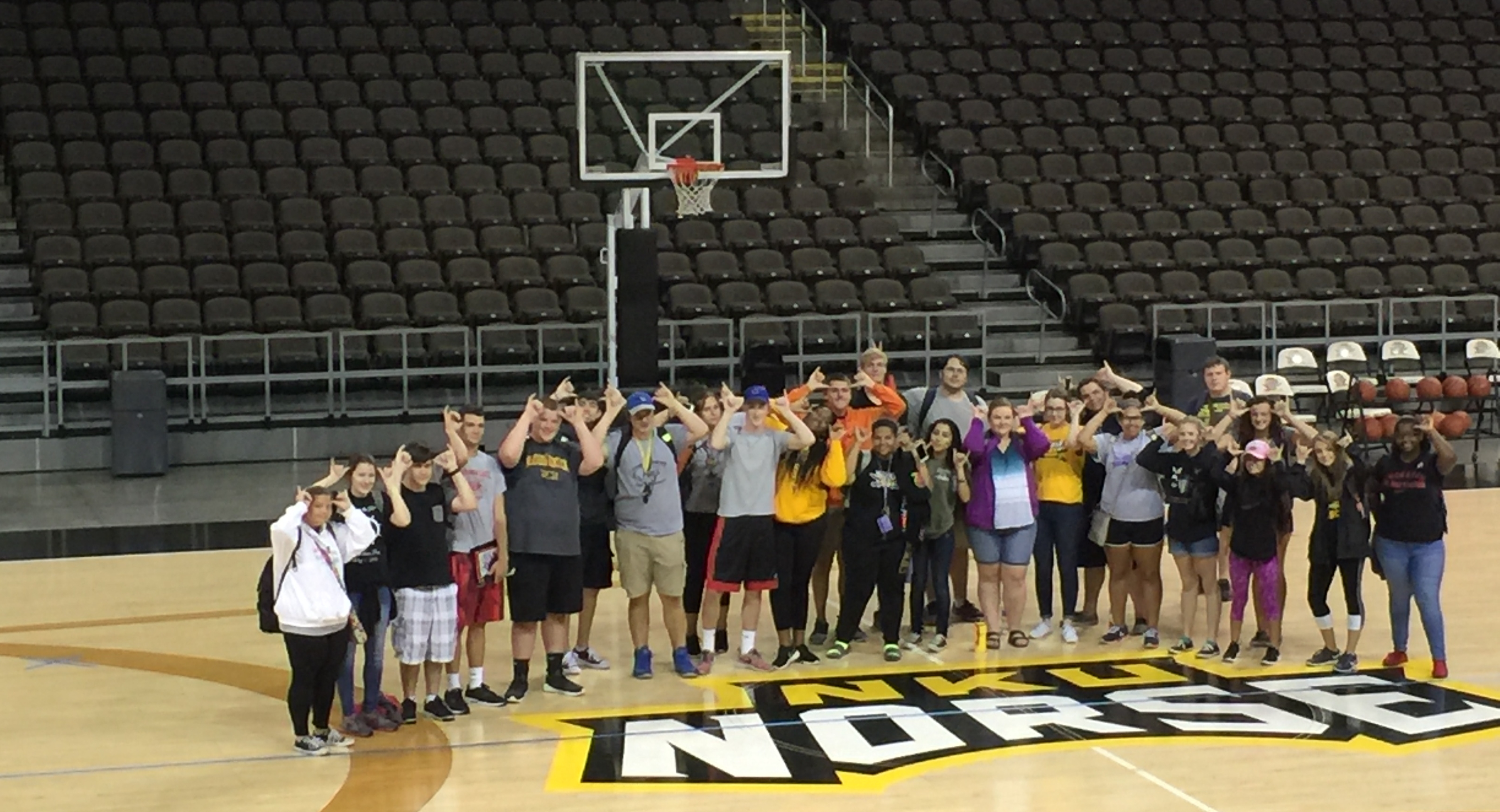 Students grouped below basketball net