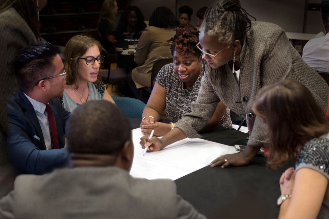 Group of professionals sitting at a table, working on a project.