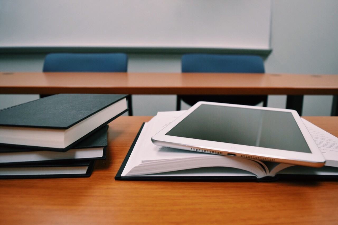 Stack of books with an iPad tablet on top.