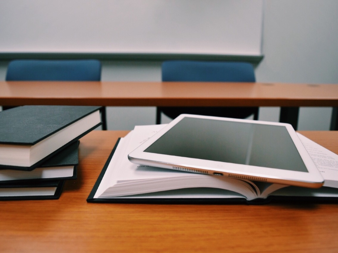 Stack of books with an iPad tablet on top.