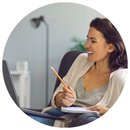 Woman with a pencil smiling at her laptop