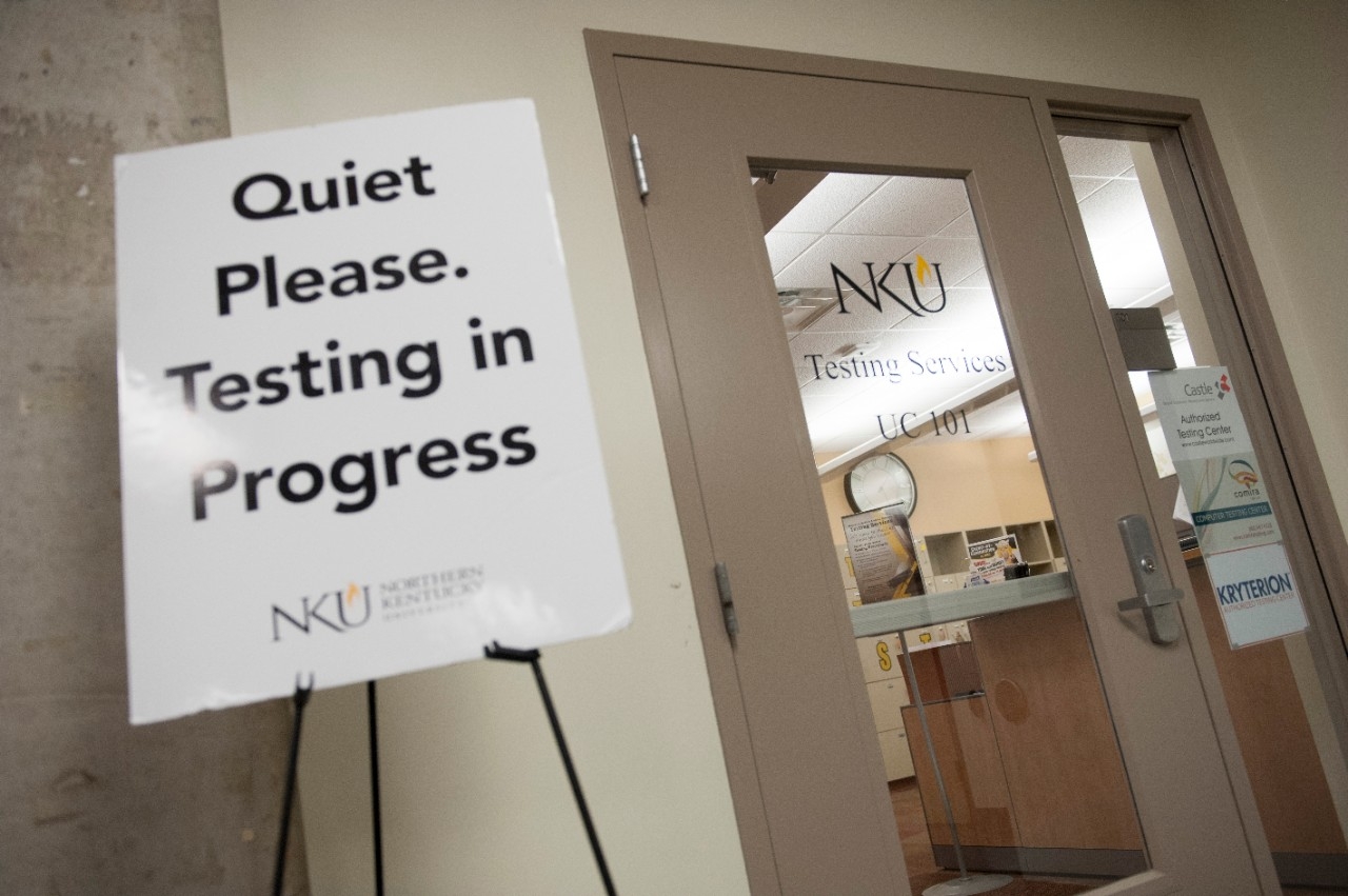 Testing Service office with a "Testing in Progress" easel sign at the front