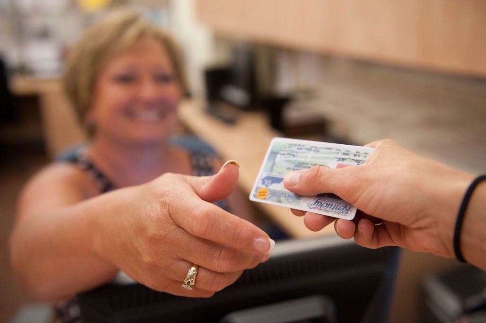 Testing Services taking ID upon arrival for an exam.