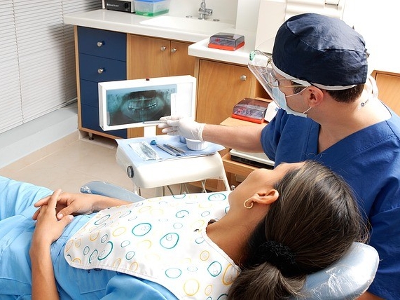 A dentist showing their patient an X-ray scan during a dental appointment.