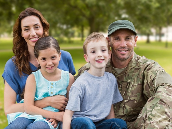 Veteran posing with family outdoors.
