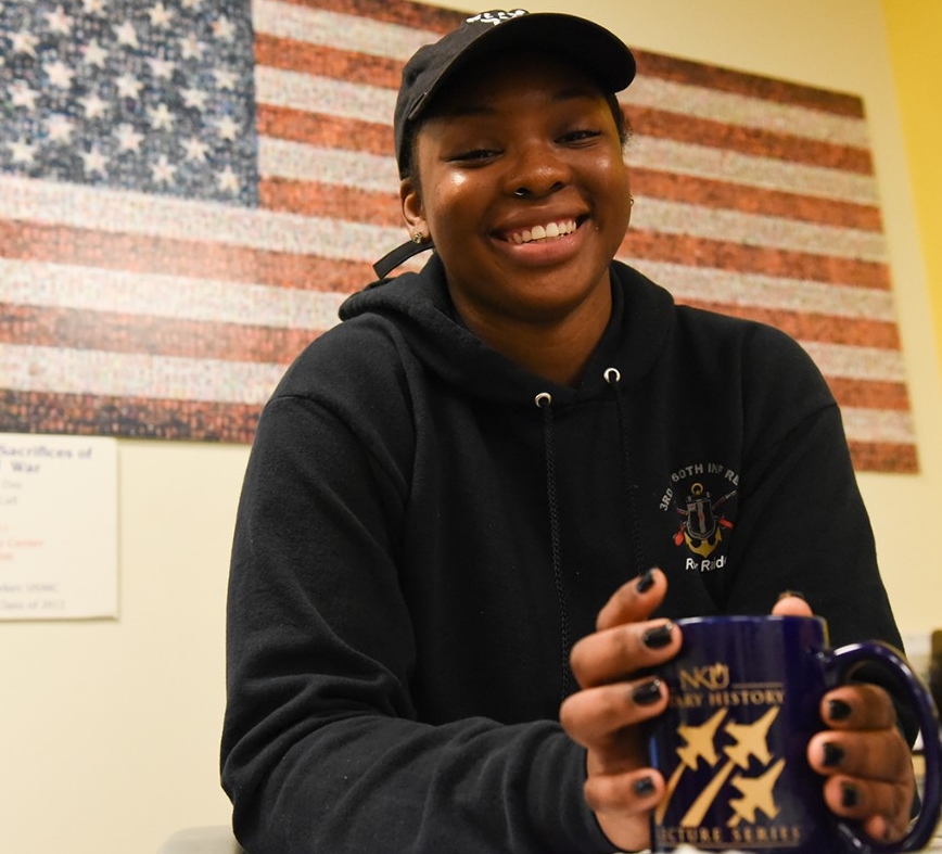 AJ Johnson sitting at a desk in front an American flag
