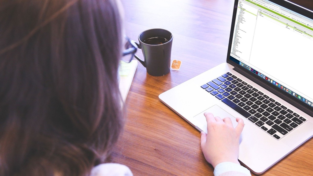 Woman using laptop with AEM showing on the screen