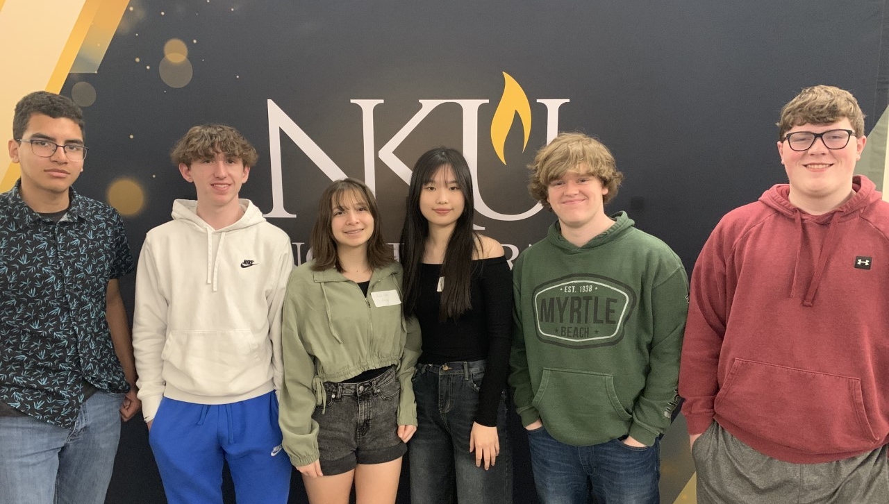 Dayton High School students standing in front of NKU sign and smiling