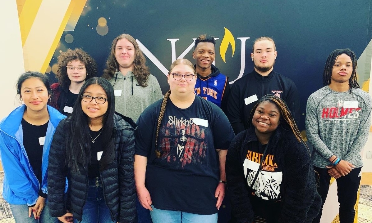 Holmes High School students standing in front of NKU sign and smiling
