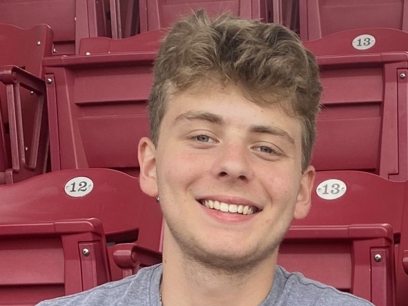 Evan Welp smiling in the stands of a Cincinnati Reds game.