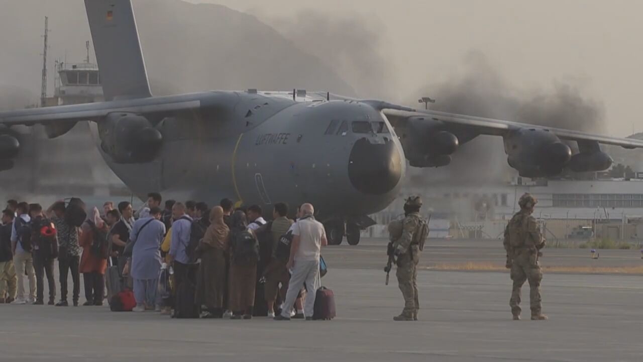 Afghanistan familiies boarding plane on tarmac