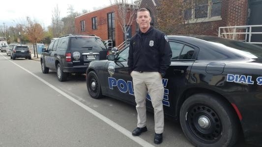 Scott Smith standing next to a police car