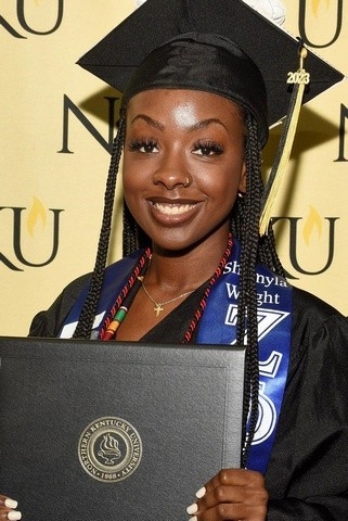 Shumyla Wright in graduation cap and gown holding diploma